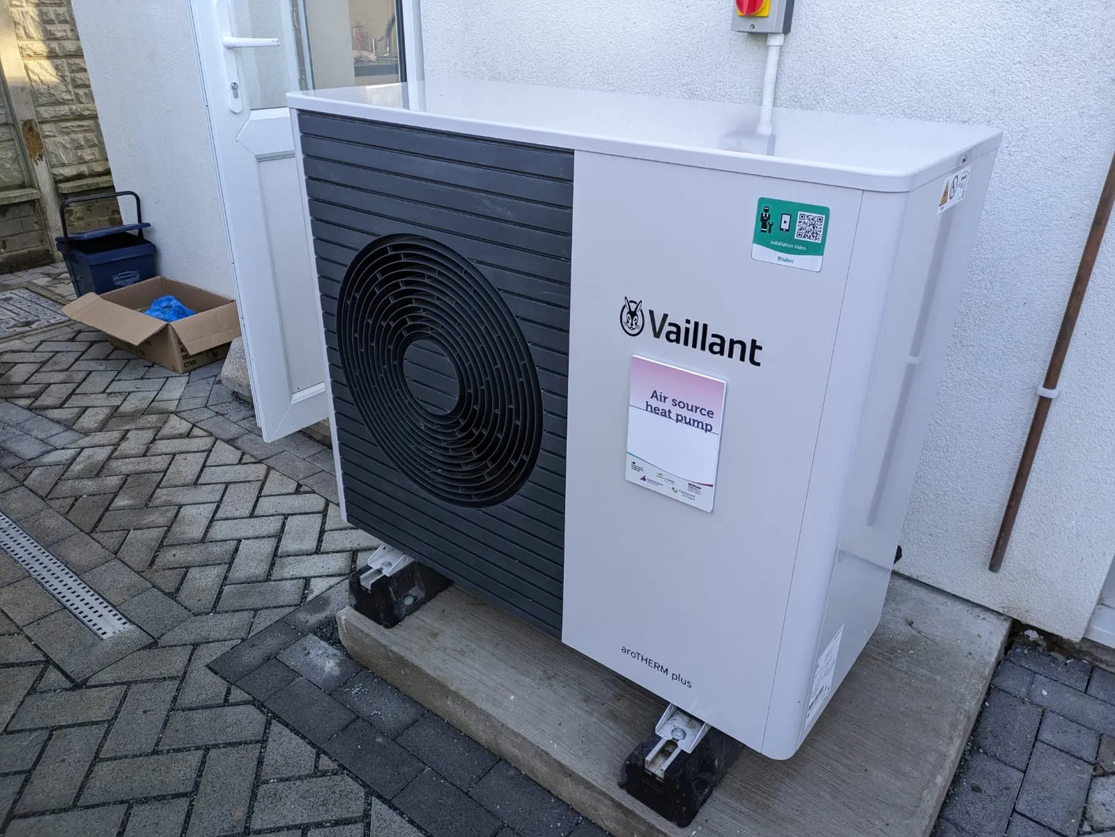 An air source heat pump installed outside a home — it keeps heating through frosty Cambridge nights, pausing briefly to defrost.
